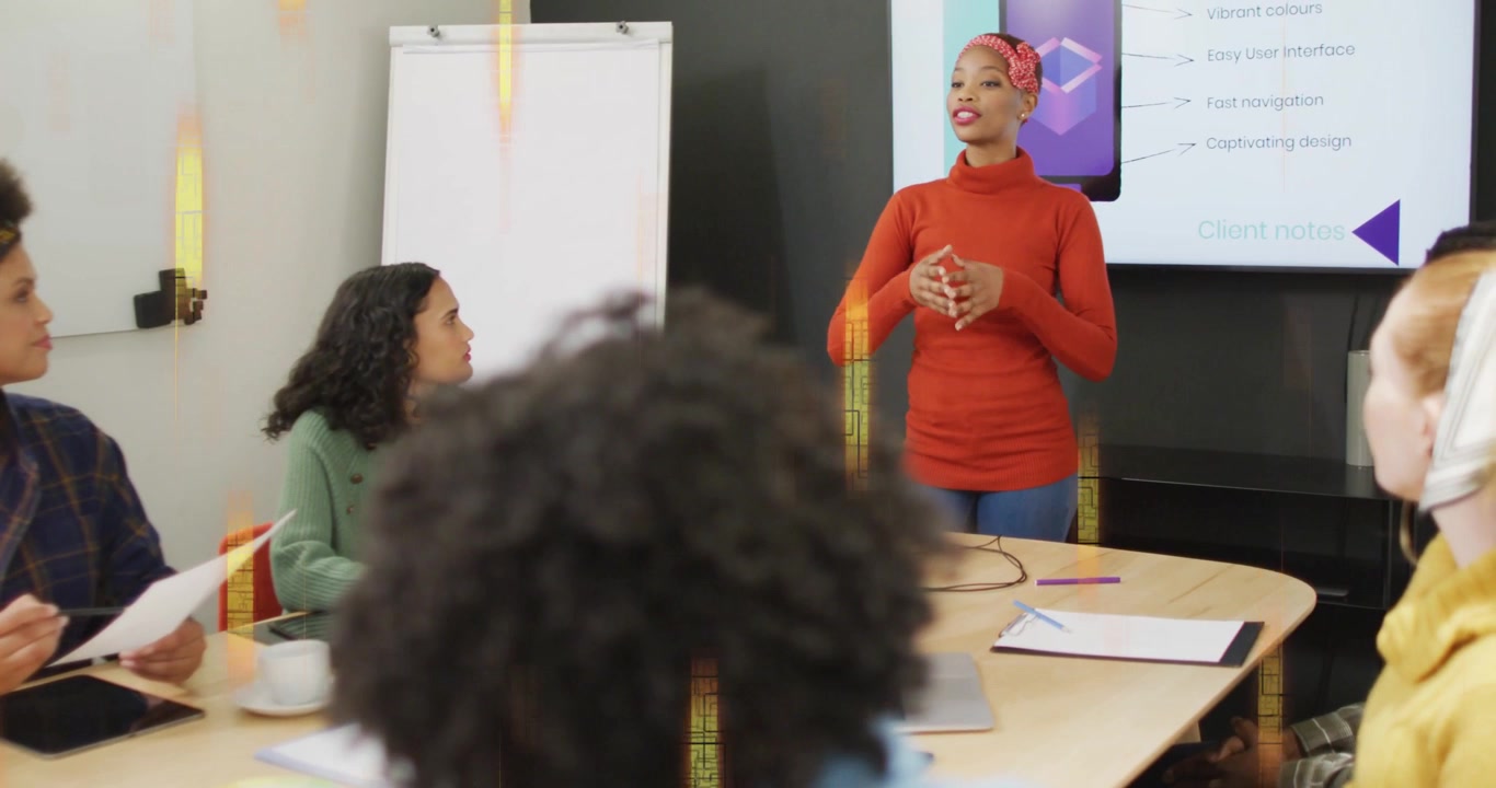 Female presenter referencing slide and flip chart, beginning presentation and guiding business team