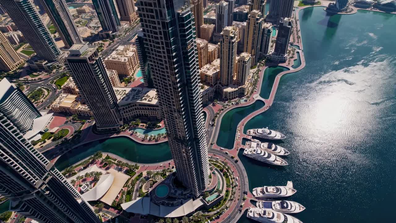Cảnh quay từ trên cao một thành phố hiện đại với những tòa nhà chọc trời và bờ sông, thể hiện kiến trúc đô thị