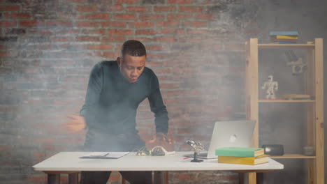 hombre afroamericano dispersa el humo de equipos en llamas