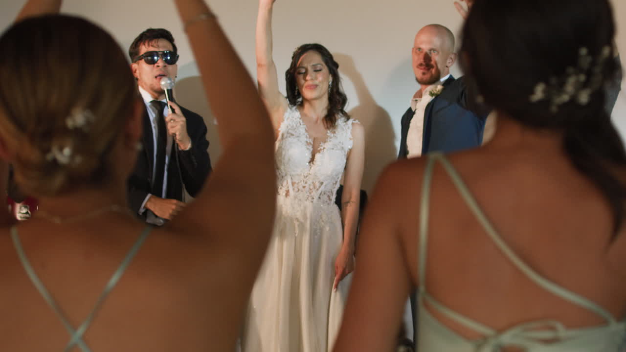 Clip of a wedding where the newlyweds dance happily with their guests and bridesmaids.