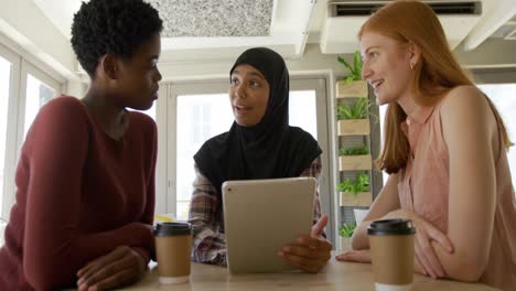 young adult female friends hanging out in a cafe