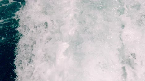 unusual and stunning high-angle pov of motorboat engine leaving sea water wake