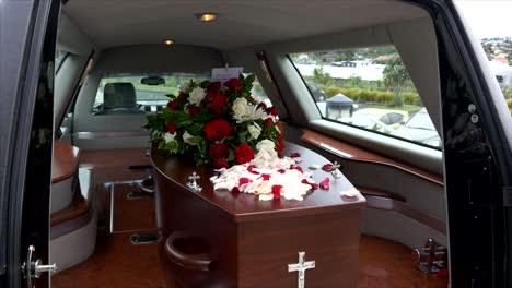 closeup shot of a funeral casket in a hearse or chapel or burial at cemetery