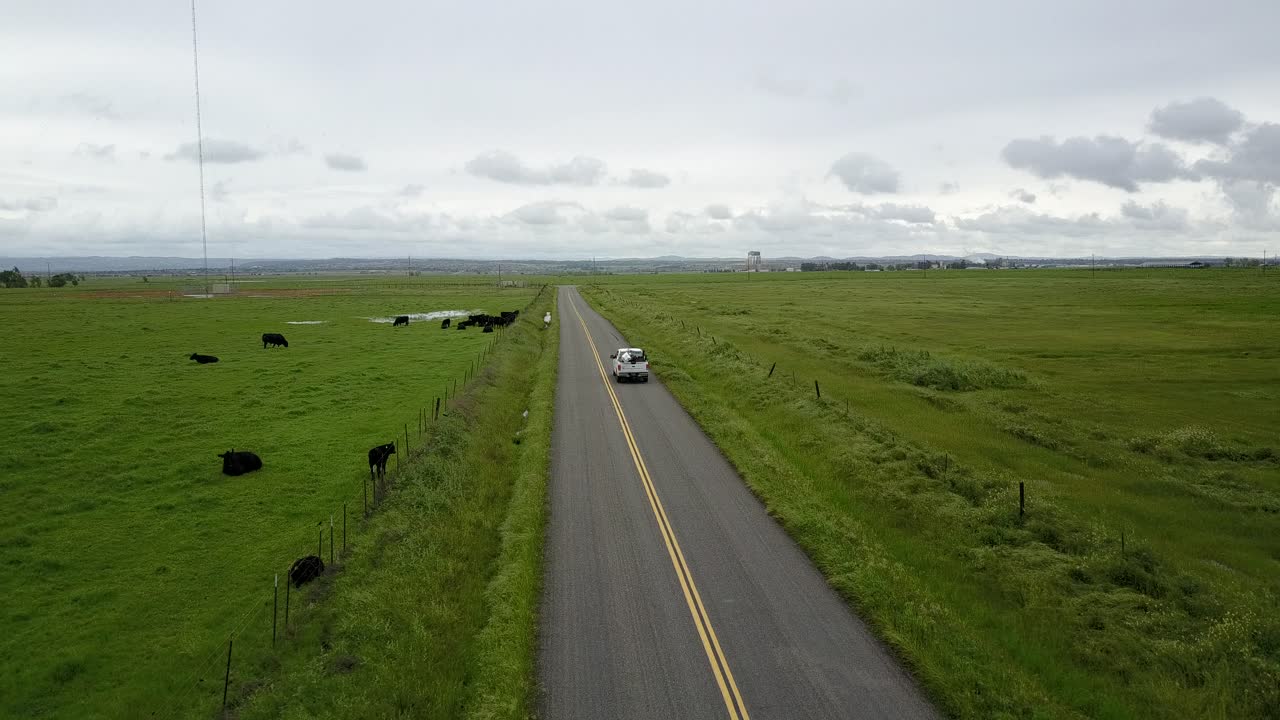 Trucks drive down rural country road