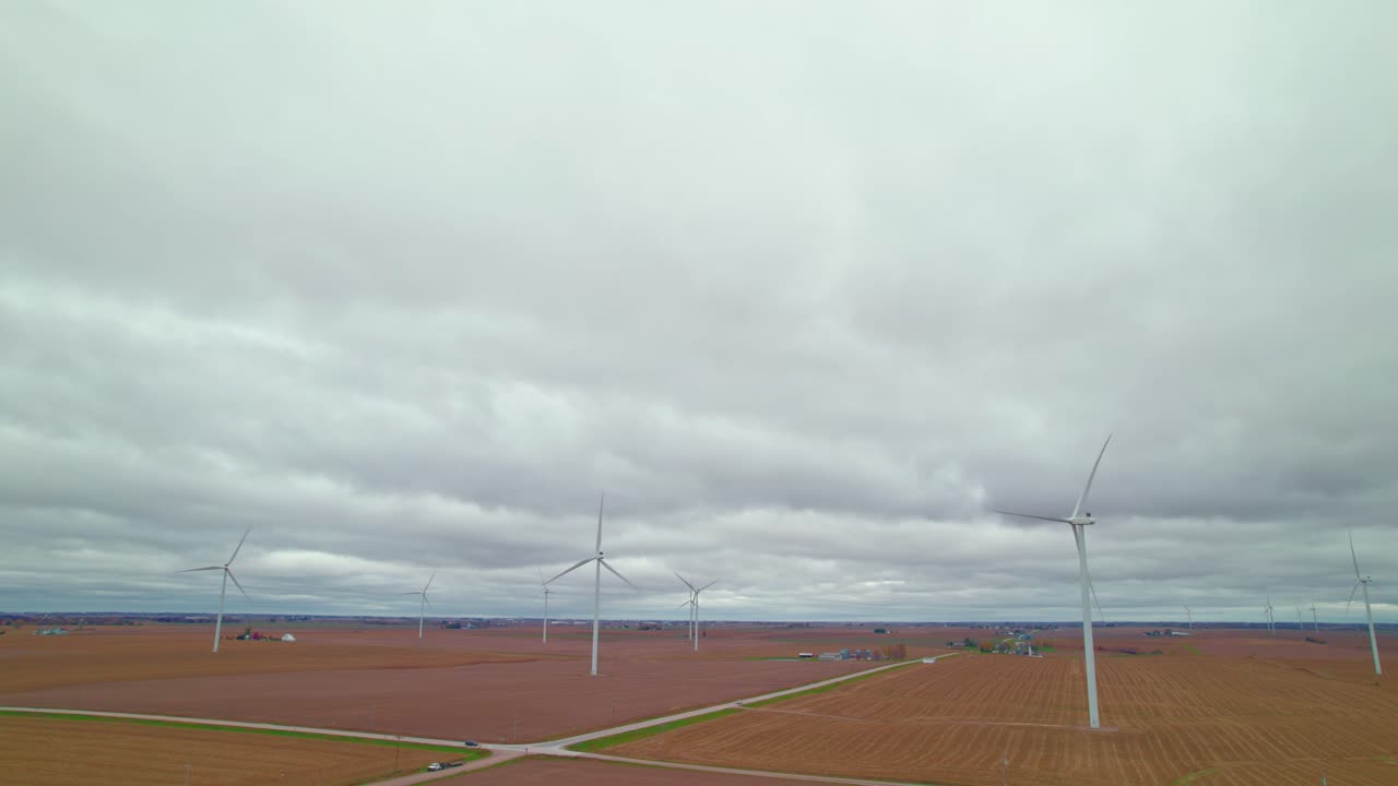 풍력 터빈은 흐린 하늘 아래 열린 농경지 위에 아 있으며, 재생 가능한 에너지가 작동하는 것을 보여줍니다. - 뉴 샤론, 아이오와