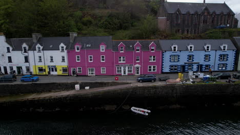 aerial view passing charming portree harbour colourful scottish coastal vacation houses on dusk waterfront