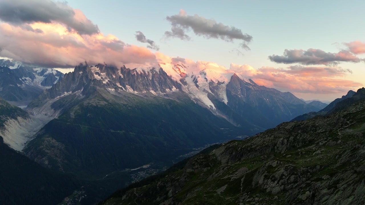 Massif du Mont Blanc au-dessus de Chamonix, Haute-Savoie, France, révélant des glaciers alpins, des pics de granite déchiquetés, des pentes de montagne escarpées et la lueur alpine du soir, survol lent par drone