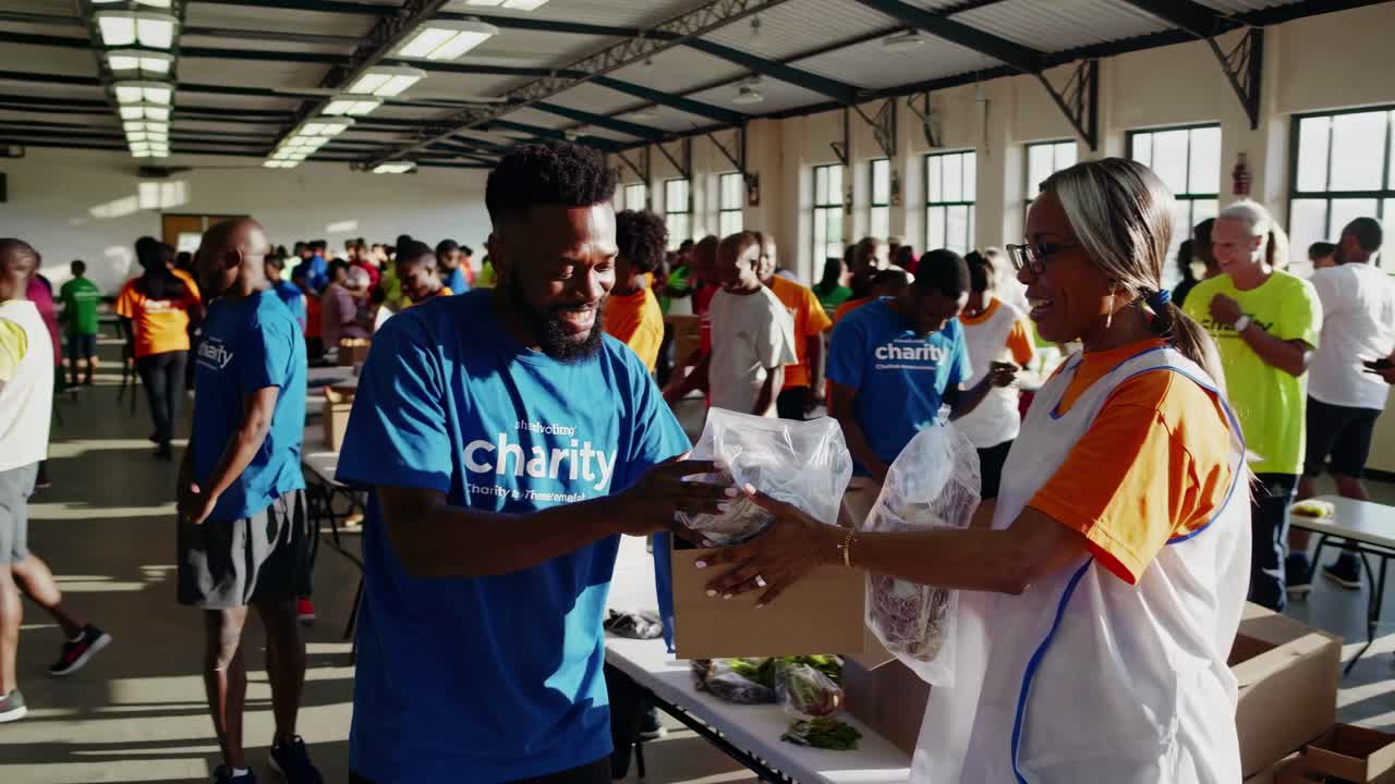 High-angle video shot of diverse volunteers in a warehouse, packing boxes for charity