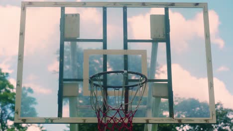 4K-Sportfilmaufnahmen-Eines-Basketballs,-Der-An-Einem-Sonnigen-Tag-Auf-Die-Felge-Trifft