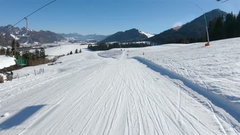 skier goes down the slope at the ski slopes and in front of him opened the mountain panorama of the valley