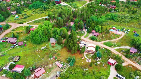 avión no tripulado vuela sobre cabañas en el bosque rodeado de bosque de pinos