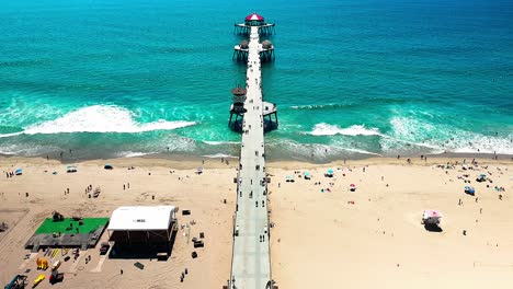 Vista-De-Drones-Volando-Lentamente-Sobre-El-Muelle-De-Pesca-En-Huntington-Beach,-California,-Con-Algunas-Personas-Caminando-Y-Autos-Conduciendo-Por-Pch,-Autopista-De-La-Costa-Del-Pacífico