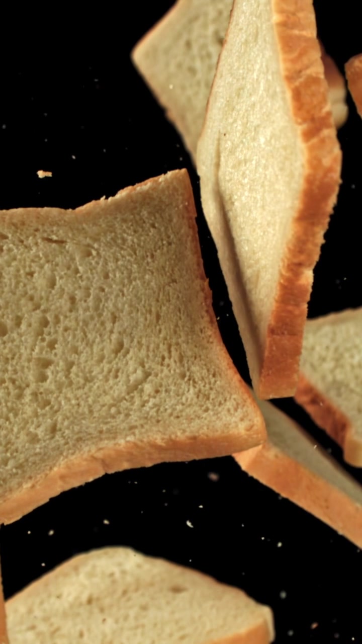 Fresh Bread Slices Falling in Slow Motion on Black Background