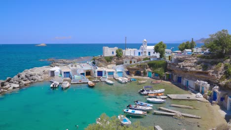 mandrakia, un pequeño pueblo de pescadores griego lleno de barcos y casas de barcos con el vibrante agua turquesa del mar egeo en la isla de milos, grecia