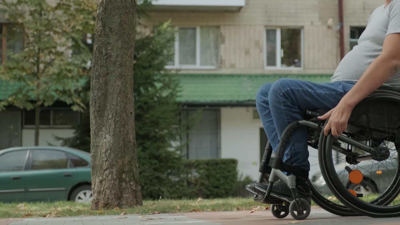 hombre con discapacidad en silla de ruedas camina por el callejón del parque