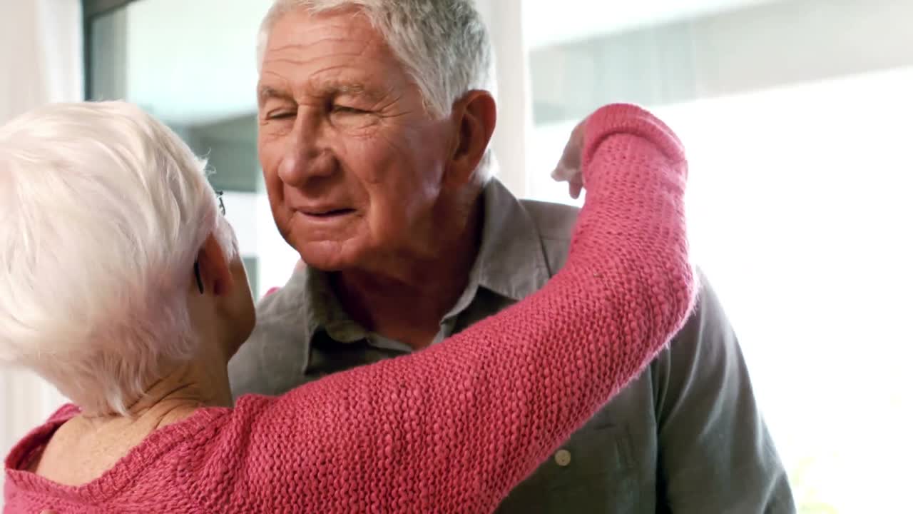 귀여운 성숙한 커플이 집에서 포옹하고 있습니다.