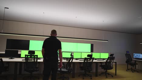 system security specialist working at system control center. room is full of green screens, chroma screen and security