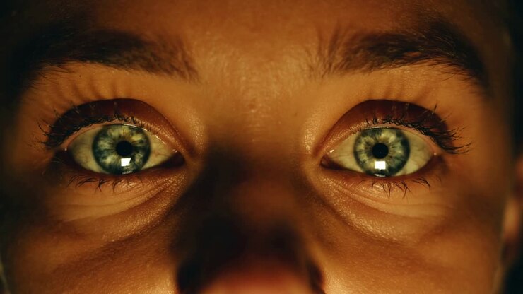 Vrouw staart naar fel licht, activeert biometrische irisscan met vierkante reflectie.
