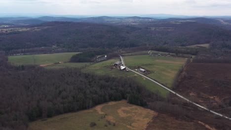 aerial wide shot of rural landscape with road and hills in background