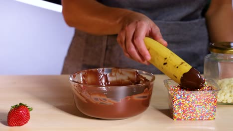 plátano cubierto de chocolate y salpicaduras de colores