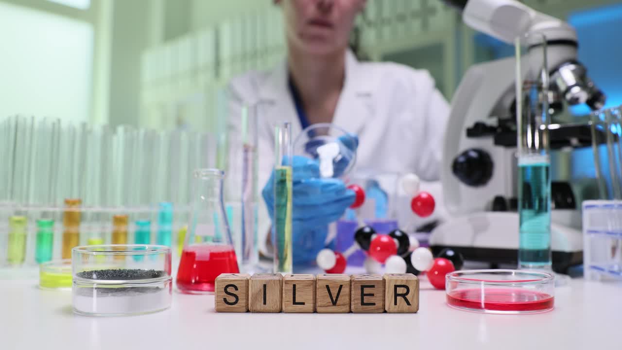 Scientist conducting chemical research in a lab with the word 'SILVER' displayed