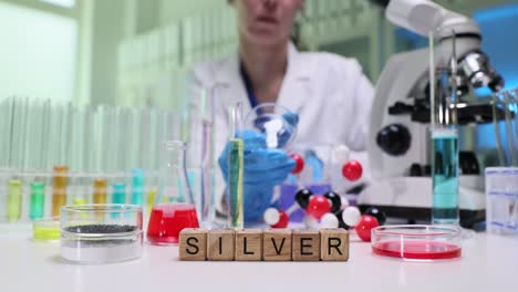 scientist conducting chemical research in a lab with the word 'silver' displayed
