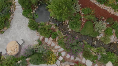 Top-down-shot-flying-up-over-a-tree-lined-stream-and-botanical-gardens-near-Malibu-horse-stables