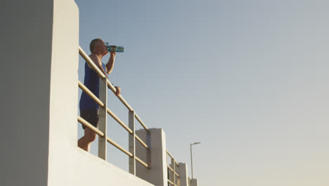 Hombre-Mayor-Bebiendo-Agua-En-El-Paseo-Marítimo