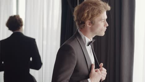 man getting ready in a tuxedo