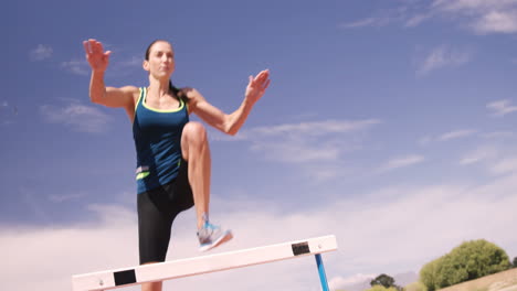 sportswoman practicing hurdle race