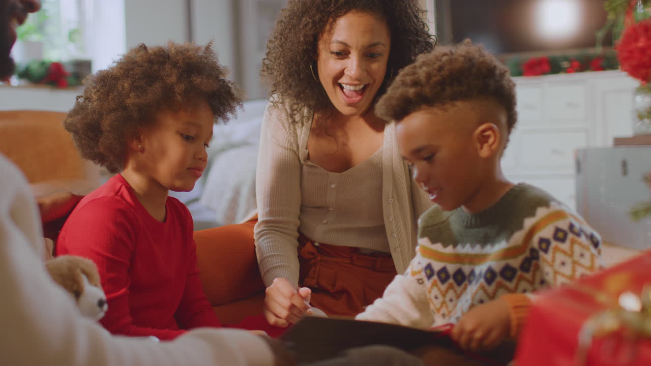 Familie tauscht zu Hause Geschenke unterm Weihnachtsbaum aus und öffnet sie.