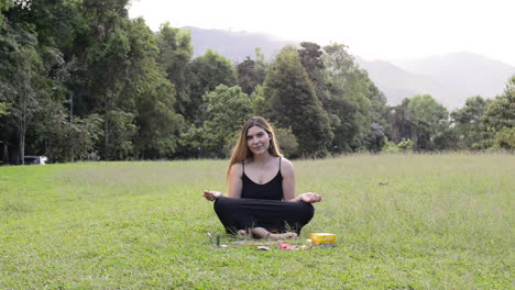 girl sitting in lotus flower pose with altar of tarot and quartz