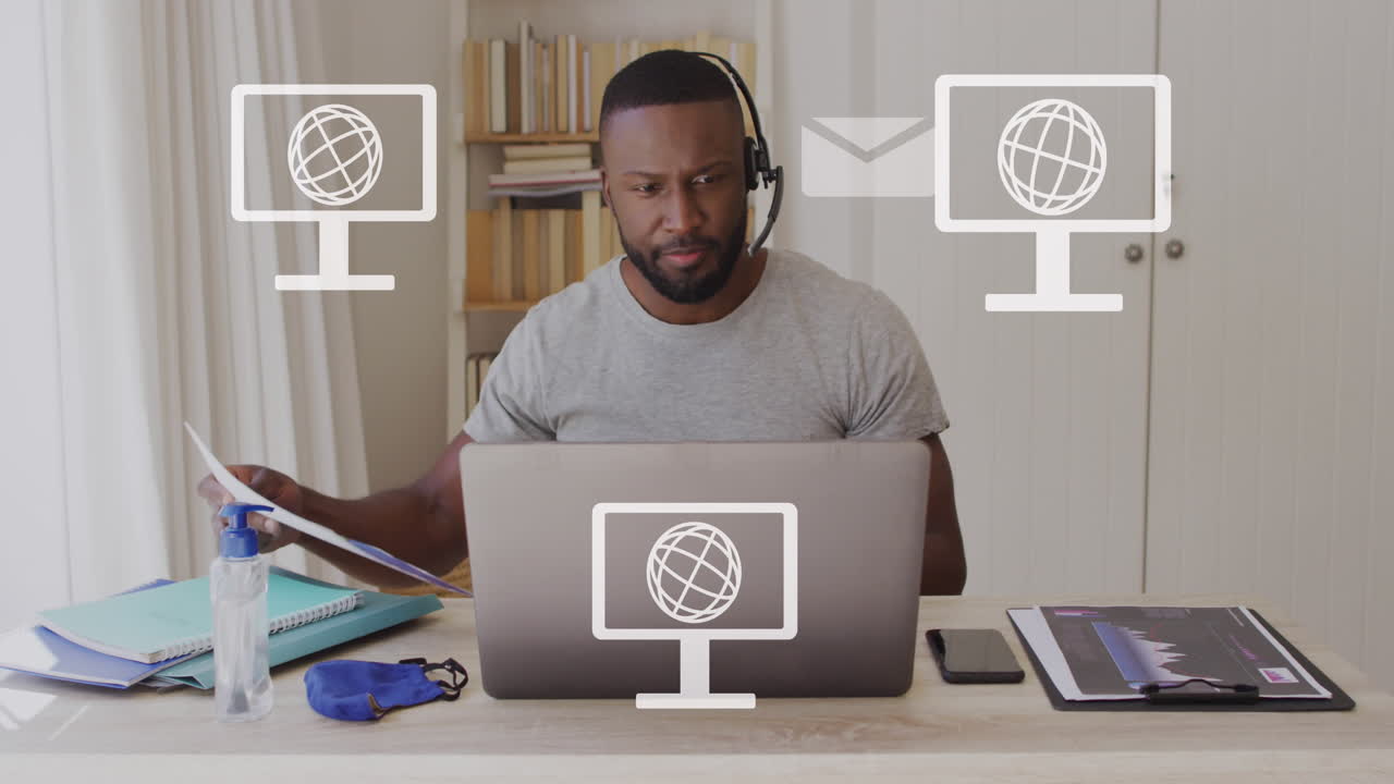 Animation of screens with globes icons over african american man using laptop