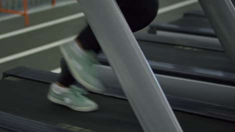 woman running on treadmill and listening to music