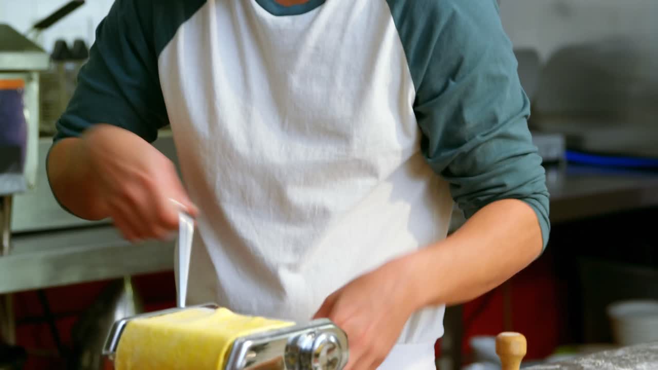 Panadero usando cortador de pasta en panadería 4k
