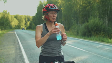 female cyclist drinking sports drink