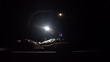 boy reading in the dark wearing a headlamp to light up the darkness