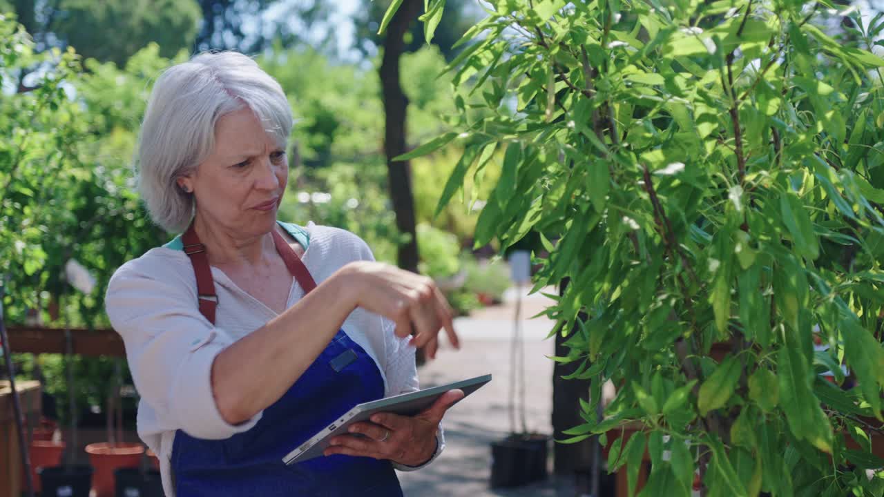 식물 종묘장에서 태블릿을 사용하는 여성