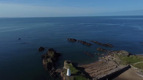 Establecimiento-De-Vista-Aérea-Del-Faro-Y-Baliza-De-La-Isla-Ynys-Llanddwyn-En-El-Tranquilo-Mar-Irlandés-Al-Amanecer.