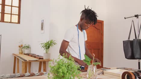 focused african american craftsman arranging wallets in leather workshop