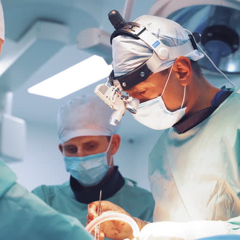 male surgeons during the operation process. close-up of specialists faces in medical masks performing an operation in surgery room in clinic.