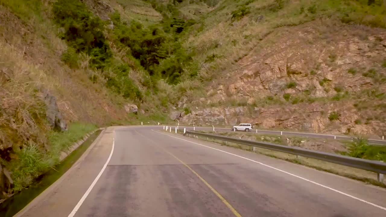 View from a vehicle moving on the road amidst beautiful mountains and valley.