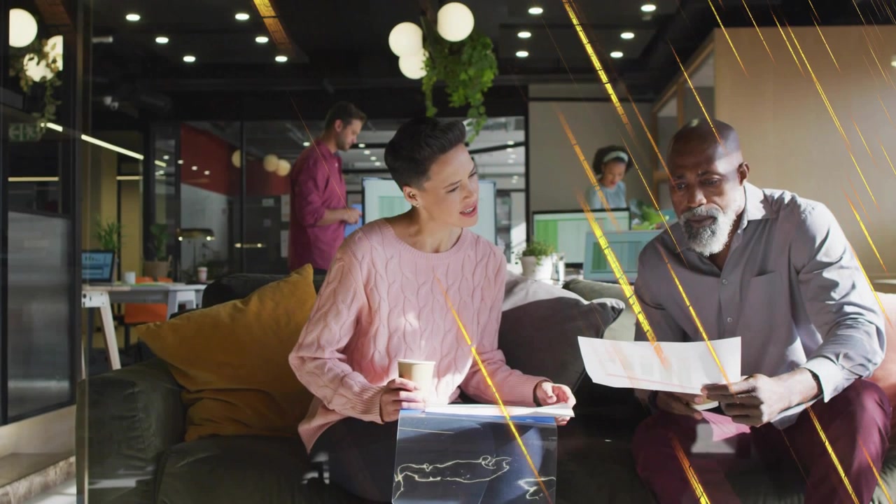 Woman pointing at paper, initiating review with man while golden streaks overlaying office lounge
