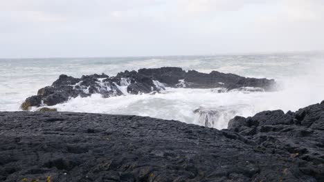 altas olas chocando contra las rocas de basalto negro en la costa de islandia