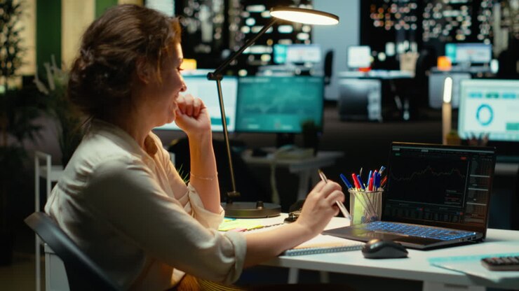 Un analista aziendale soddisfatto dell'andamento positivo dei grafici forex dopo l'orario di lavoro