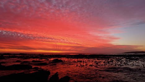 Nubes-Naranjas-Iluminadas-Y-Reflejo-Del-Océano,-Vibrante-Puesta-De-Sol-Costera