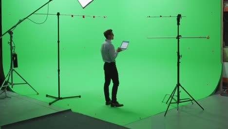 handsome young man wearing casual jeans and shirt, using laptop computer in green screen mock up chroma key studio. business, corporate office, work, technology concept.