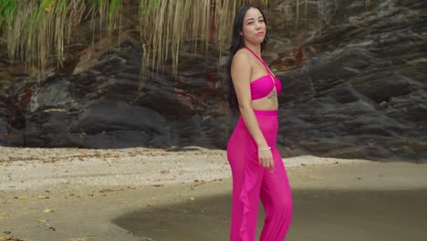 A-Hispanic-girl-in-a-pink-bikini-enjoys-the-lush,-tropical-beach-on-an-island-in-Trinidad