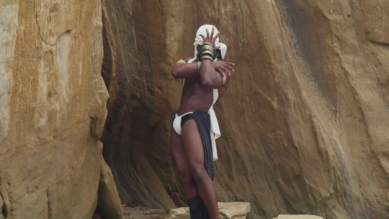 Kaslı ve koyu tenli erkek bir cosplayer plajın tadını çıkarıyor.