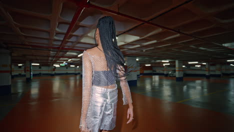 trendy girl dancing evening parking back view. woman posing at night portrait